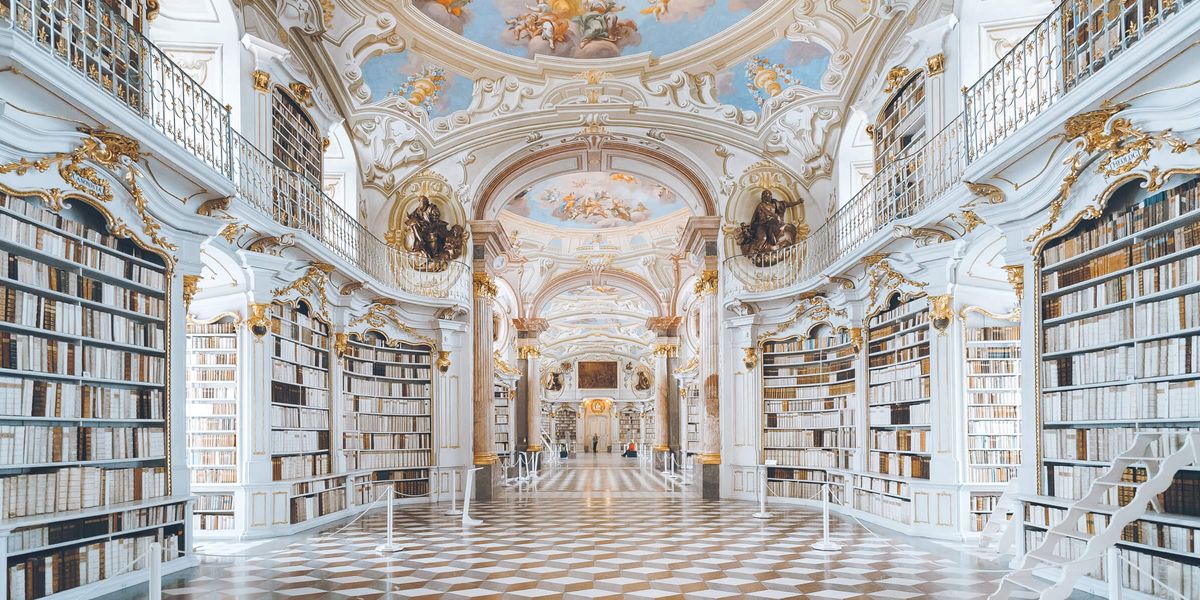 Grand library with marble pillars, gold details, and fresco ceiling