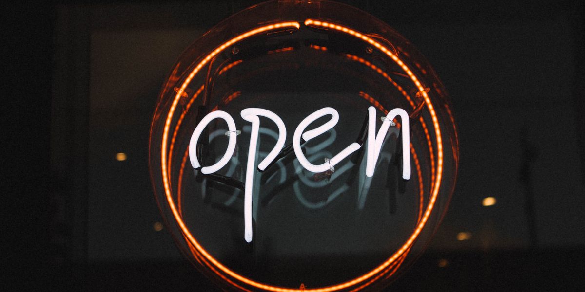 Photo of a glowing circular neon "open" sign